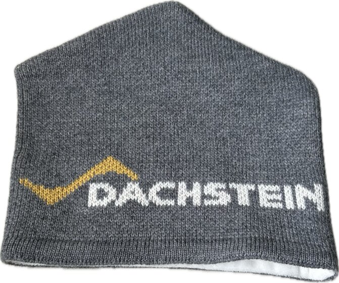 Graue Strickmütze mit gelbem Zackenmuster und weißem Dachstein-Schriftzug auf flacher Oberfläche | © Planai-Hochwurzen-Bahnen Gesellschaft m.b.H.