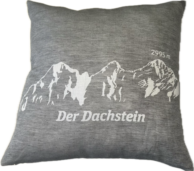 Dunkelgraues Zierkissen mit hellem Dachstein-Aufdruck, Beschriftung „Der Dachstein“ und Höhe 2995 m | © Planai-Hochwurzen-Bahnen Gesellschaft m.b.H.