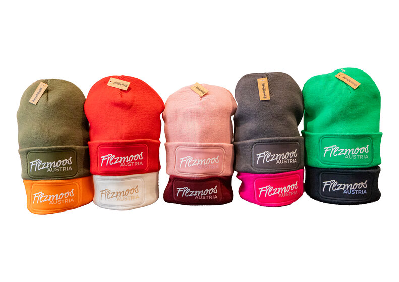 Fünf Strickhauben mit Filzmoos-Austria Logo in verschiedenen Farben vor hellem Hintergrund. | © Bergbahnen Filzmoos GmbH