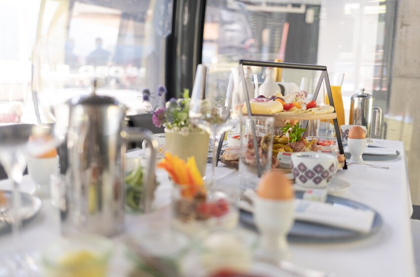 Reich gedeckter Tisch mit Eiern, Käse, Wurst, Obst und Orangensaft in einer verglasten Berggondel | © Großarler Bergbahnen GmbH & Co KG