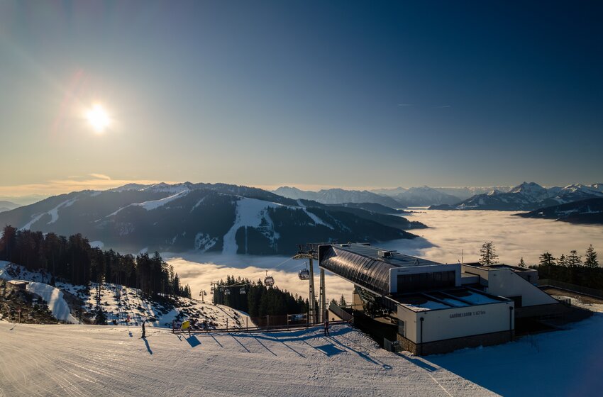 Gabühelbahn at Hochkönig with gondolas and ski slope above a sea of clouds, with snow-covered mountains beyond | © Hochkönig Bergbahnen GmbH