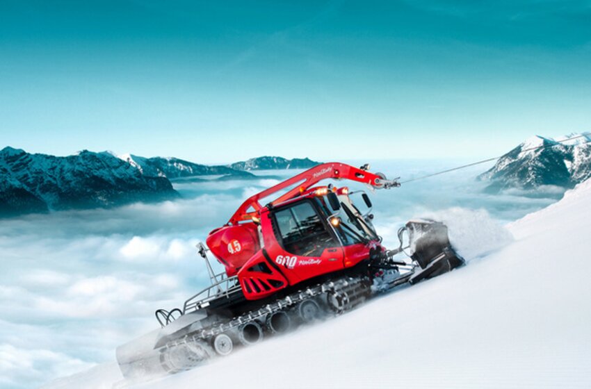 Red snow groomer with winch ascends steep slope in the Alps | © Hochkönig Bergbahnen GmbH