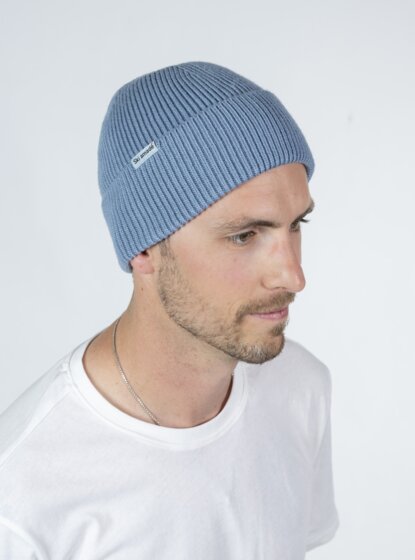 Man in white shirt wearing light blue Ski amadé beanie in profile view, bright backdrop | © Ski amadé GmbH / Lorenz Masser