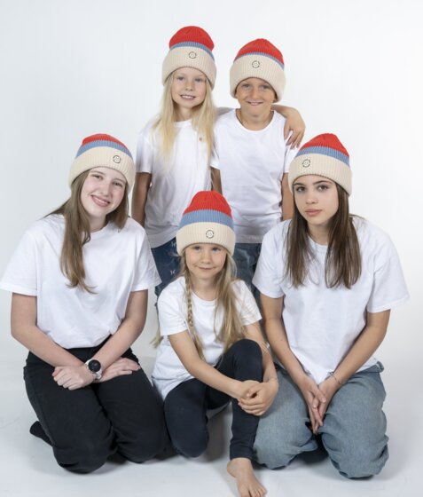 Five kids in red Mountain Vibe Ski amadé beanies and white shirts in photo studio | © Ski amadé GmbH / Lorenz Masser