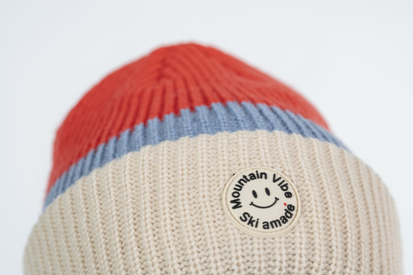 Beige, red and blue beanie with round Mountain Vibe patch and Ski amadé logo | © Ski amadé GmbH / Lorenz Masser