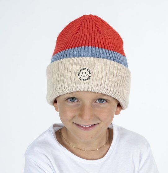 Boy in red-beige Mountain Vibe Ski amadé beanie and white shirt in studio | © Ski amadé GmbH / Lorenz Masser