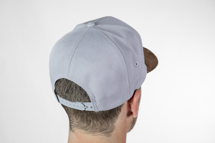 Angled rear view of a grey baseball cap with adjustable snapback closure on a man's head | © Ski amadé GmbH / Lorenz Masser