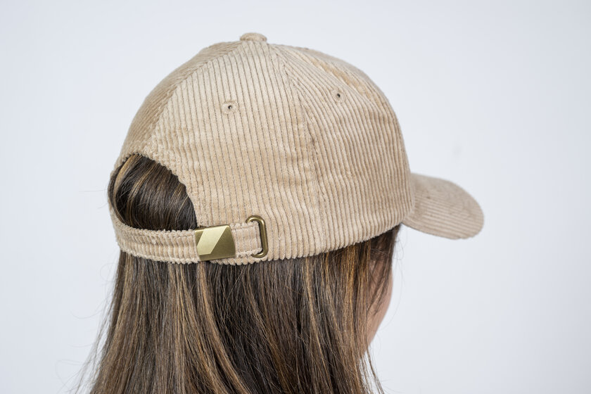 Back view of a beige cord baseball cap with adjustable metal clasp worn by a girl | © Ski amadé GmbH / Lorenz Masser