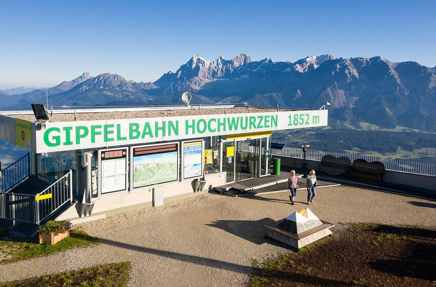 Hochwurzen summit lift at 1852 m with Dachstein view | © Planai-Hochwurzen-Bahnen GesmbH Summit station of Hochwurzen gondola at 1852 m with panoramic view and two hikers in the morning light | © Planai-Hochwurzen-Bahnen GesmbH