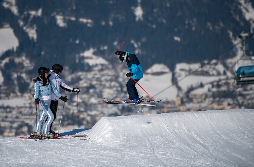 Junger Skifahrer springt im Snowpark über Kicker, zwei Personen beobachten ihn am Pistenrand. | © Zauchensee Liftgesellschaft Benedikt Scheffer GmbH