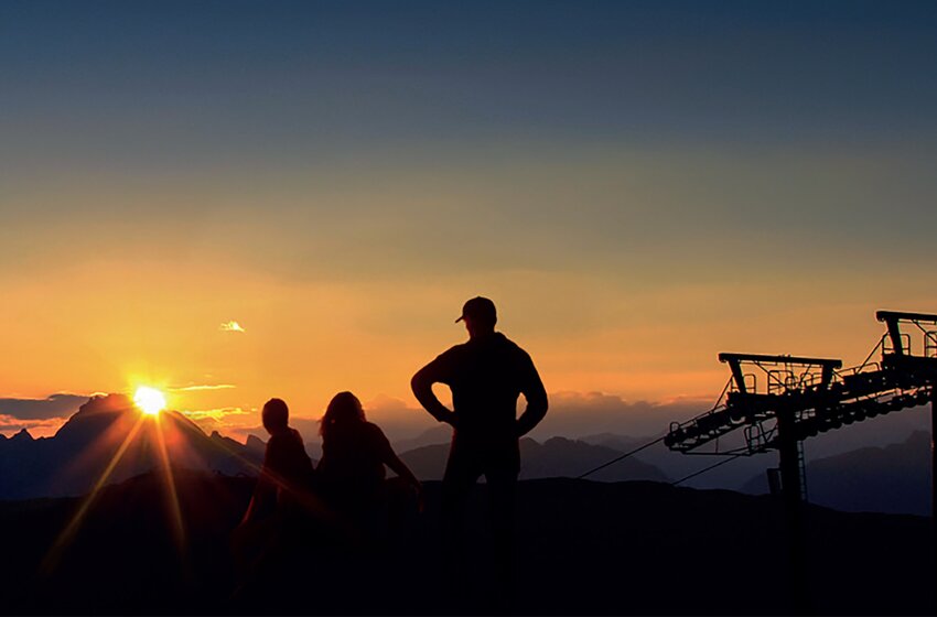 Three people and cable car silhouette at colorful sunrise in alpine mountain landscape | © Zauchensee Liftgesellschaft Benedikt Scheffer GmbH